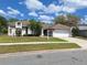 Charming single-story home with a well-manicured lawn, mature trees, and attached two-car garage on a sunny day at 3125 Timucua Cir, Orlando, FL 32837
