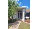 Inviting front entrance with a decorative storm door, side window, and a tiled walkway amidst lush tropical landscaping at 3125 Timucua Cir, Orlando, FL 32837