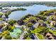 Aerial view showcasing community tennis courts, lake, lush landscaping, and residential buildings at 366 Waterside Dr # 102, Altamonte Springs, FL 32701