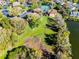 An aerial view of a residential community featuring a lake, tennis courts, and lush greenery at 366 Waterside Dr # 102, Altamonte Springs, FL 32701