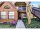 Charming townhome entrance with brick facade, colorful flower garden, and stairway to upper level at 366 Waterside Dr # 102, Altamonte Springs, FL 32701