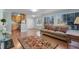 Open living room with hardwood flooring, a comfortable sofa, and a partial view of the kitchen at 366 Waterside Dr # 102, Altamonte Springs, FL 32701