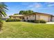 Inviting brick home with attached garage, lush lawn and landscaping under clear skies at 398 Troon Ct, Winter Haven, FL 33884