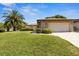 Lovely brick home with a well-manicured lawn, mature landscaping, and a large two-car garage at 398 Troon Ct, Winter Haven, FL 33884