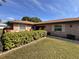 Charming brick home featuring manicured shrubs, a verdant lawn, and mature trees at 398 Troon Ct, Winter Haven, FL 33884