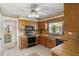 Classic kitchen with wood cabinets, tile flooring, and modern appliances for a functional space at 398 Troon Ct, Winter Haven, FL 33884