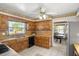 Traditional kitchen featuring wooden cabinets, tile floors, and views into the dining area at 398 Troon Ct, Winter Haven, FL 33884