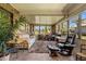 Bright sunroom with brick wall, tile floors, multiple windows, and comfortable seating at 398 Troon Ct, Winter Haven, FL 33884