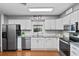 Well-lit kitchen features stainless steel appliances, granite countertops, and white cabinetry at 427 N Lakeview Ave, Winter Garden, FL 34787