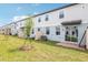 View of the backyard featuring green grass and a tree in a row of townhouses with modern exteriors at 4337 Switchgrass Ln, St Cloud, FL 34772