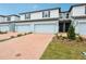 Modern townhomes showcasing brick driveways leading to attached garages and well-maintained landscaping at 4337 Switchgrass Ln, St Cloud, FL 34772