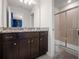 Bathroom featuring a vanity with granite countertop, dark cabinets, and a glass-enclosed shower at 4361 Lana Ave, Davenport, FL 33897