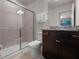 Bathroom featuring granite counters, dark wood cabinets, a glass shower, and toilet in a functional layout at 4361 Lana Ave, Davenport, FL 33897