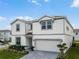 Front view of a charming two-story home with manicured landscaping and a paved driveway at 4361 Lana Ave, Davenport, FL 33897