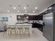 Modern kitchen featuring dark wood cabinets, a center island, and stainless steel appliances at 4361 Lana Ave, Davenport, FL 33897