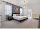 Comfortable main bedroom with a king bed, crib, modern light fixture, and decorative wall art at 4361 Lana Ave, Davenport, FL 33897