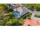 Aerial view of a home with a pool, screened lanai, manicured lawn, and lush landscaping in a residential neighborhood at 703 Cricklewood Ter, Lake Mary, FL 32746