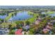 Aerial view of the property with a serene lake and golf course, nestled among lush green trees and community homes at 703 Cricklewood Ter, Lake Mary, FL 32746