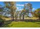 Expansive backyard with mature trees and manicured lawn, providing a picturesque setting near the water at 703 Cricklewood Ter, Lake Mary, FL 32746