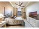 This bedroom is equipped with a ceiling fan, a large window, a TV, and a bed at 703 Cricklewood Ter, Lake Mary, FL 32746