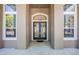 Close up of the front door with sidelights and arched window at 703 Cricklewood Ter, Lake Mary, FL 32746