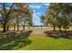 Scenic golf course view with lush green lawns, mature trees, and a tranquil lake on a clear day at 703 Cricklewood Ter, Lake Mary, FL 32746
