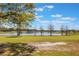 Picturesque view of the lush green golf course and serene lake, framed by trees under a bright blue sky at 703 Cricklewood Ter, Lake Mary, FL 32746