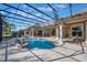 A luxurious screened-in pool area with travertine pavers, columns, and plenty of space for outdoor lounging at 703 Cricklewood Ter, Lake Mary, FL 32746