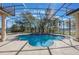 Enclosed pool area featuring a uniquely shaped pool, travertine deck, and screened enclosure at 703 Cricklewood Ter, Lake Mary, FL 32746