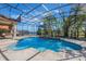 An inviting screened-in pool featuring elegant fountains, lush landscaping, and serene lake views at 703 Cricklewood Ter, Lake Mary, FL 32746