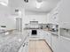 Well-lit kitchen with white cabinets, granite counters, and stainless steel appliances at 7108 Stockholm Way, Orlando, FL 32822