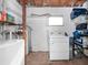 Functional laundry room with washer, dryer, and shelving for storage at 7108 Stockholm Way, Orlando, FL 32822