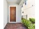 Inviting front porch featuring a wood door and brick flooring at 8006 Hoylake Dr, Orlando, FL 32832