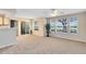 Sun-filled living room featuring neutral carpet, a sliding door, and large windows offering peaceful views at 1017 S Hiawassee Rd # 3718, Orlando, FL 32835