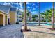 Community pool surrounded by beautiful landscaping, multiple buildings and sunny skies at 1017 S Hiawassee Rd # 3718, Orlando, FL 32835