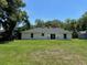 Back exterior view of the single-story home with large backyard, sliding glass doors, and neutral paint at 120 S Chandler Ave, Deland, FL 32724
