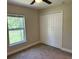Carpeted bedroom featuring a large window and closet with folding doors at 120 S Chandler Ave, Deland, FL 32724