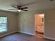 Bedroom with view to bathroom featuring neutral paint, carpet flooring and a ceiling fan at 120 S Chandler Ave, Deland, FL 32724