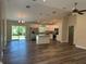 Open-concept kitchen with white cabinets, stainless steel appliances, island and wood grain flooring at 120 S Chandler Ave, Deland, FL 32724