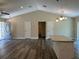 Spacious living area with hard surface flooring, ceiling fan, and adjacent granite island in kitchen at 120 S Chandler Ave, Deland, FL 32724