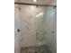 Close-up of bathroom shower with patterned tile and a frameless glass door at 120 S Chandler Ave, Deland, FL 32724