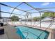 Relaxing enclosed pool with a screen and a palm tree in the background at 130 Hillside Dr, Davenport, FL 33897