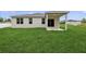 Backyard view of a modern home with a well-maintained lawn and covered porch at 13405 Sw 88Th Ter # 53, Ocala, FL 34473