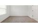A bright bedroom has neutral walls and carpet, with a window letting in natural light at 13405 Sw 88Th Ter # 53, Ocala, FL 34473