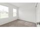 Bright bedroom with neutral walls and carpet, featuring two windows with blinds at 13405 Sw 88Th Ter # 53, Ocala, FL 34473