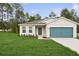 Charming one-story home with a well-manicured lawn and a pop of color from the teal garage door at 13405 Sw 88Th Ter # 53, Ocala, FL 34473