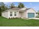 Inviting one-story home featuring lush green lawn and a modern teal garage door at 13405 Sw 88Th Ter # 53, Ocala, FL 34473
