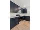 This modern kitchen features dark cabinets, stainless steel appliances, light countertops, and wood-look tile flooring at 13405 Sw 88Th Ter # 53, Ocala, FL 34473