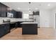 Open concept kitchen featuring dark cabinets, stainless steel appliances, an island, and wood-look tile flooring at 13405 Sw 88Th Ter # 53, Ocala, FL 34473