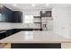 Modern kitchen with an island, navy blue cabinets, stainless steel appliances, and quartz countertops at 13405 Sw 88Th Ter # 53, Ocala, FL 34473